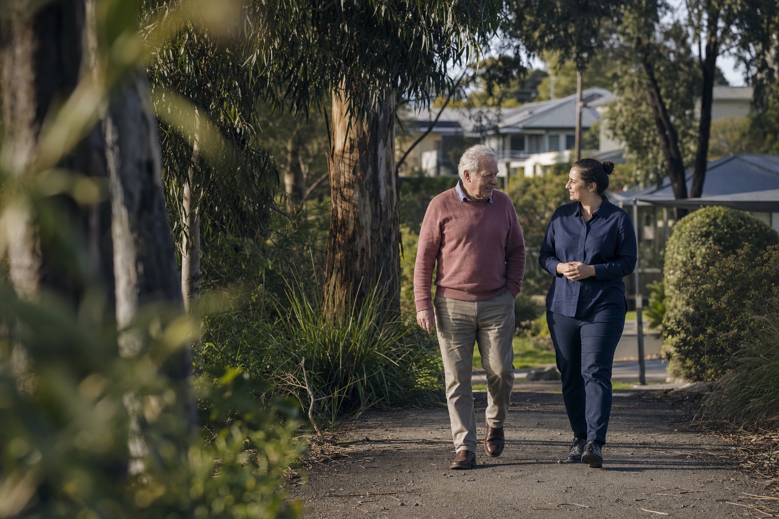 A community care worker walking with an older client